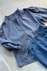 Flat lay of check shirt with frill detail on neckline and button up front