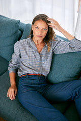 model wears the check print shirt with frill etail