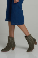 A model wearing olive suede boots