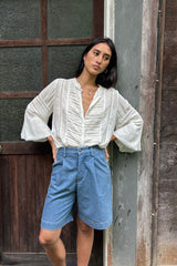 Model wears tailored bermuda style shorts in denim look