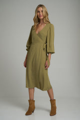 A model wearing a feminine green wrap midi dress