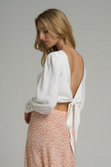 A model wearing a reversible ivory wrap top with embroidery