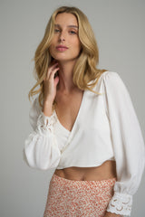 A model wearing a ivory reversible wrap top