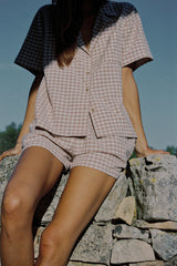 A woman wearing a beige check top