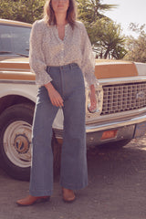 Olivia wearing the Lou Lou Jeans in a mid vintage look wash in her garden in California.