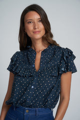 A woman wearing a navy print top with pintuck details