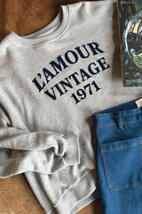 Flat lay of crew neck jumper with navy flocked logo