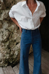 Woman wearing mid blue denim jeans with wide leg fit in vintage wash