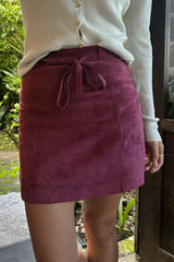 Girl wearing a paneled suede skirt with belt and a knit top