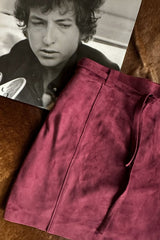 Flat lay image of a suede mini skirt in wine