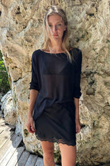 Model wears semi sheer transeasonal knit top in black by Lilya