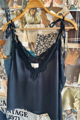 Wall hang of lace cami top with tie shoulders