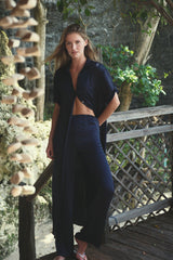 Model wears stylish navy satin shirt dress with matching pants for day-to-night styling.