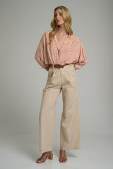 A model wearing high waisted beige dress pants