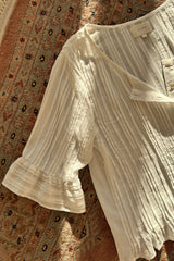 Flat lay of pleated details and frill sleeve on the Sonora Blouse by LILYA.