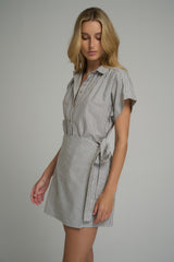 A woman wearing a black and white cotton mini dress