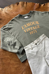 Flat lay of oversized crew neck sweater with L'Amour Vintage exclusive logo