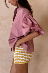 Model wears the flounce shirt styled with the charm knit shorts for a playful summer outfit.