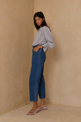 Cropped blue denim jeans styled with feminine blouse