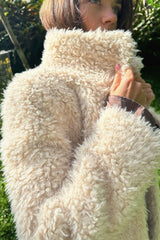 Close-up of a fluffy white garment held by a person outdoors.