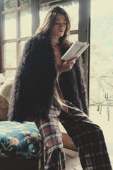 model wears oversized furry winter coat in chocolate