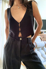 Girl wearing black sleeveless knit top with clasp detail