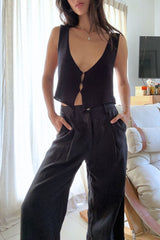 Girl wears black linen tailored pants with button and zip closure with black knit top