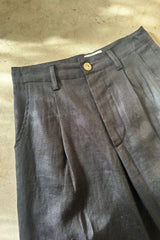 Flat lay of linen pants with pleat detail and zip button closure