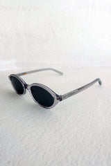 Sunglasses with oval lenses on a textured white surface