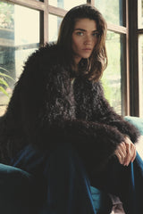 model wears soft plush fur jacket in dark brown with denim