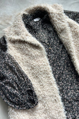 Flat lay of Oakie floral blouse by LILYA layered with fluffy vest for winter style