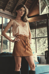 model wears a tie-shoulder satin camisole with brown suede mini skirt by LILYA