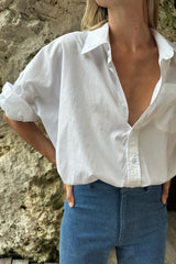 Airy white shirt styled with tailored blue pants and sandals