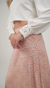 A model wearing a cropped wrap top with embroidery detail