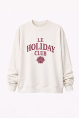 White sweatshirt with 'Le Holiday Club' text and shell graphic on a white background