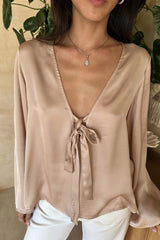 Woman wearing an antique Rose blouse styled with neutral tailoring and soft layers