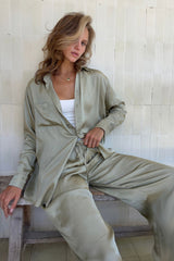 Model wears green satin shirt set for resortwear styling.