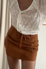Close up of the Nova suede mini skirt with panel detail and tie waist