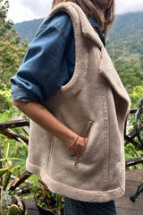 Girl wears oat vest layered over denim shirt in mountains