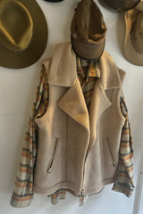 Wall hanf of stylish winter vest layered over check shirt
