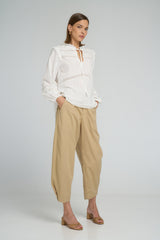 Boho-style white lace top featuring tie neck design and relaxed long sleeve fit