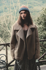 Model wears a warm winter shearling coat in the mountains