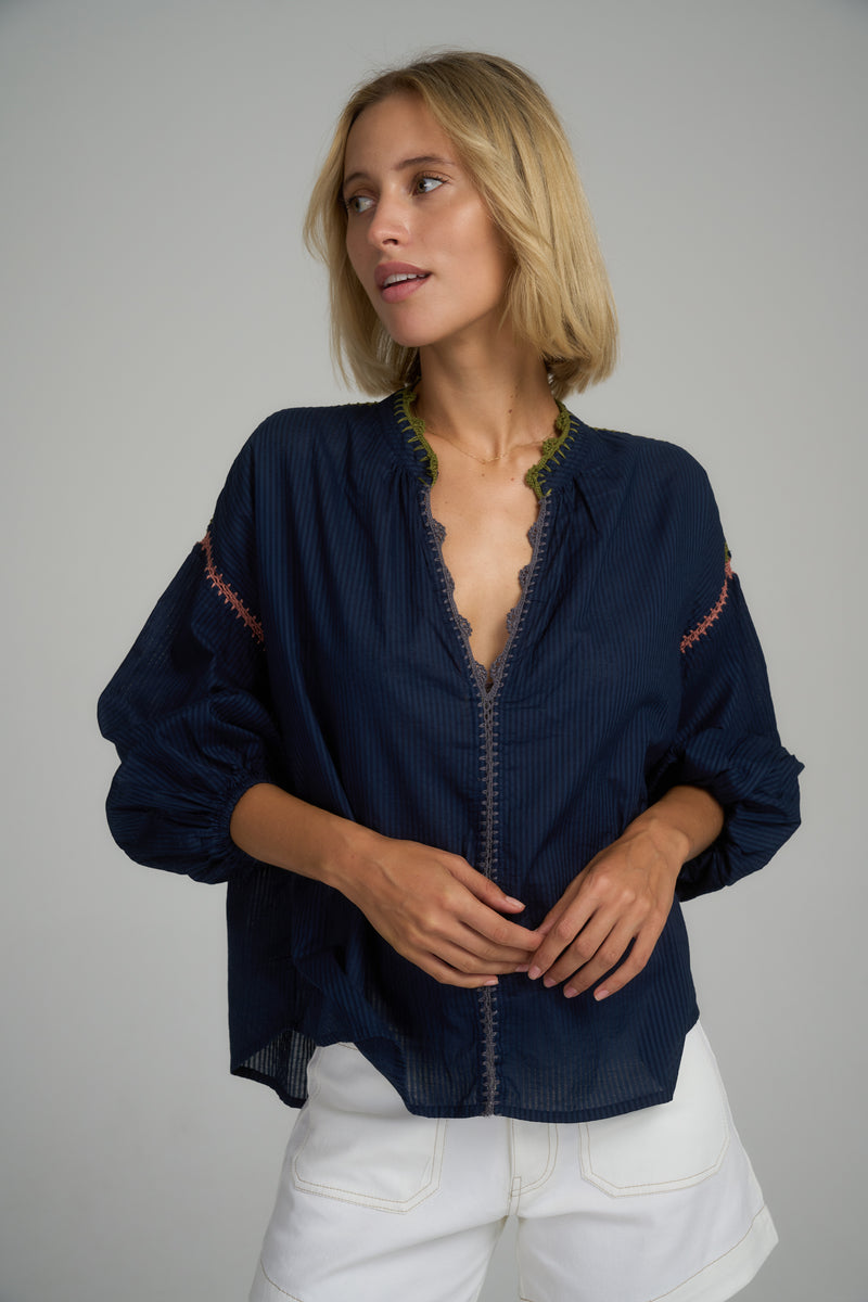 A model wearing a classic navy cotton top with crochet