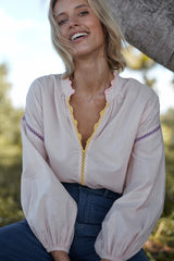 A woman wearing a spring striped blouse with crochet detail