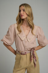 A model wearing a vintage inspired natural blouse