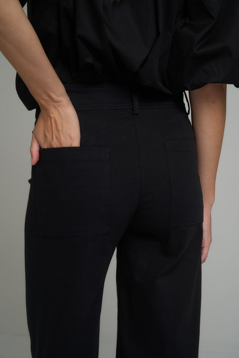 A model wearing classic black cotton pants