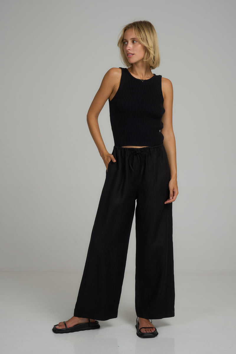 A model wearing black linen wide leg pants in Australia