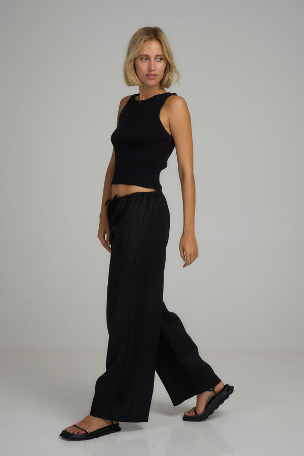 A model wearing black linen beach pants