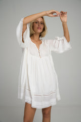 A model wearing a white cotton boho mini dress