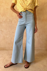 Model wears light salty blue vintage denim jeans with a high waist and wide leg fit.
